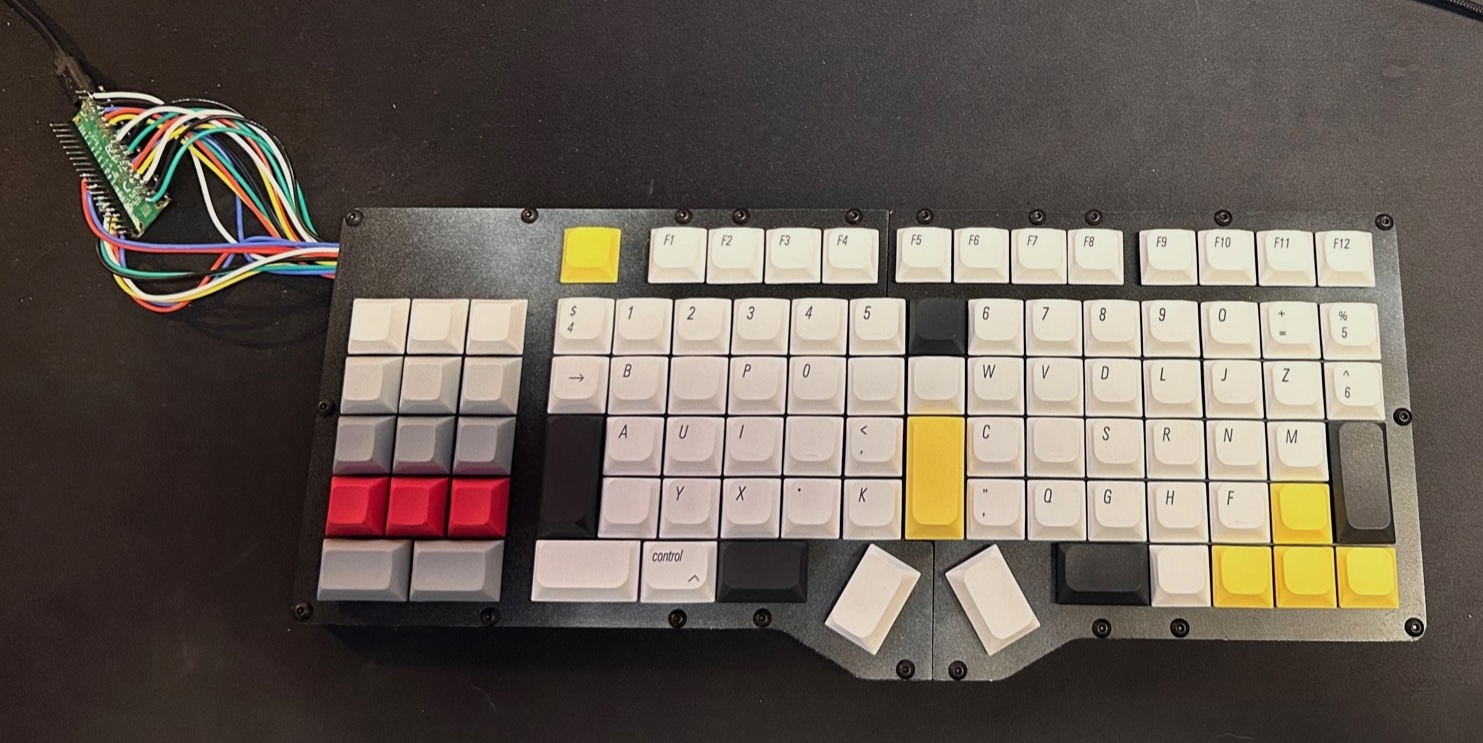 My first handmade Matrx keyboard, with exposed wires connecting the keys to a controller beside it.